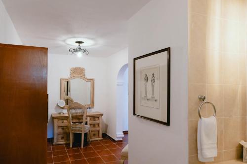 a bathroom with a vanity and a mirror and a sink at Hotel Hacienda La Cieneguita in San Miguel de Allende