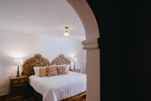 a bedroom with a bed with white sheets and pillows at Hotel Hacienda La Cieneguita in San Miguel de Allende