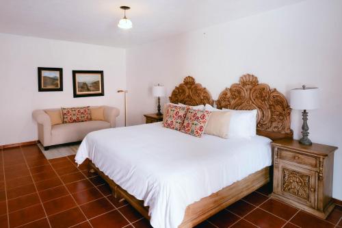 a bedroom with a large bed and a couch at Hotel Hacienda La Cieneguita in San Miguel de Allende