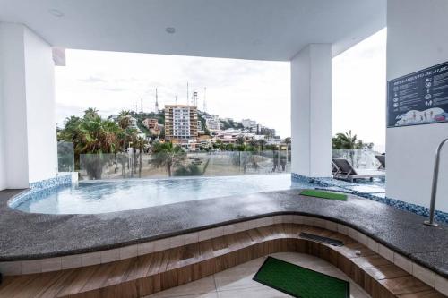a swimming pool with a view of a city at Elegante depa frente al malecón y cerca del centro in Mazatlán
