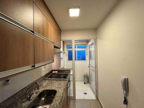 a small kitchen with a sink and a shower at LK1005 Espaçoso Apartamento Com Vista da Vibrante Rua Augusta in Sao Paulo