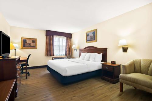 a hotel room with a large bed and a chair at Best Western StateLine Lodge in West Siloam Springs