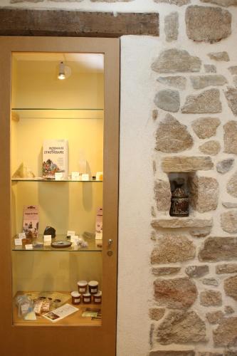 a room with a stone wall and a shelf with desserts at Aux Pierres Magiques in Saint-Laurent-de-Chamousset