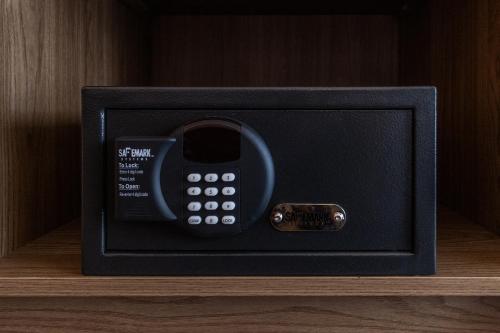 a black safe with a cell phone in it at Atrium Hotel Vancouver in Vancouver