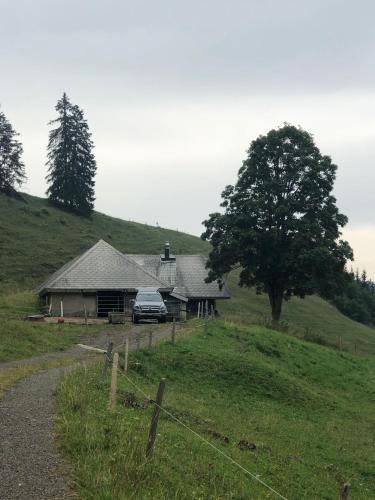 a car parked in front of a house on a hill at Staldenhaus Riggisalp in Plaffeien