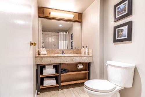 a bathroom with a toilet and a sink at Atrium Hotel Vancouver in Vancouver