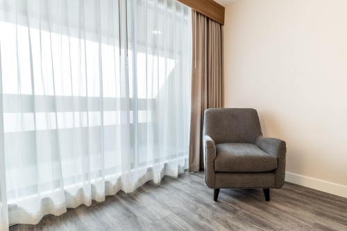 a chair in a room with a large window at Atrium Hotel Vancouver in Vancouver