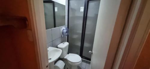 a bathroom with a toilet and a sink and a shower at Hotel Fish in Concepción