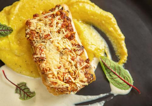 a piece of food on a plate with a fork at Meliá Campinas in Campinas