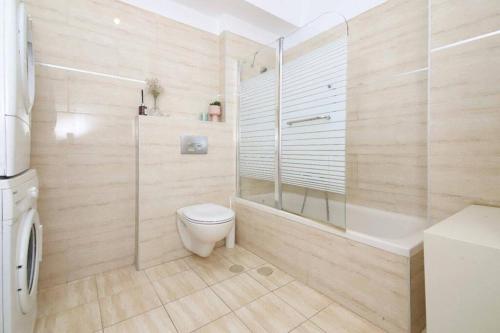 a bathroom with a shower and a toilet and a tub at Spacious 2BR Apartment with Private Balcony, Free Parking in Jerusalem
