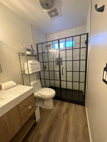 a bathroom with a toilet and a glass shower door at YoBee! Park Reservation Included! Heart of Yosemite - Homey Studios and Breakfast in Yosemite West