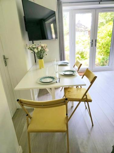 a dining room table with two plates and two chairs at Wordsworth - Peaceful Place in Bournemouth