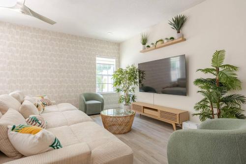 a living room with a couch and a tv at 4 Bedroom House Near Downtown Tampa Sleeps 12 Pool Private Patio Pet Friendly in Tampa