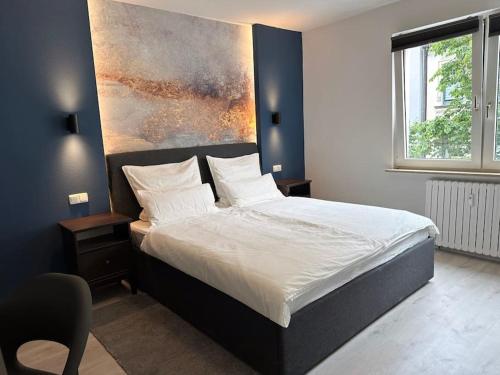 a bedroom with a bed with a painting on the wall at City Apartment with WIFI, Kitchen and 4K TV in Essen