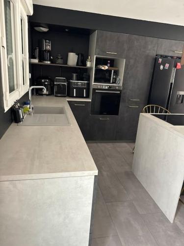 une cuisine avec un évier et une cuisinière four supérieur dans l'établissement Maisons 3 chambres avec piscine, à Nissan-lez-Enserune