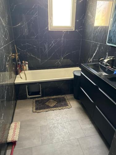 une salle de bain avec une baignoire et un lavabo dans l'établissement Maisons 3 chambres avec piscine, à Nissan-lez-Enserune