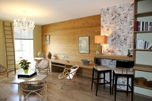 a living room with a table and chairs at Aux Pierres Magiques in Saint-Laurent-de-Chamousset