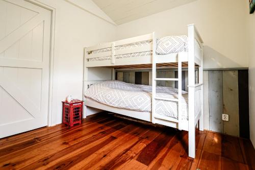 a bedroom with two bunk beds and a wooden floor at Huisje Elfde Wijk in Rheezerveen