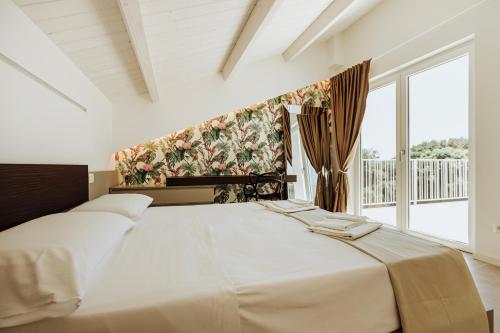 a bedroom with a large bed and a large window at Suite 106 in Vasto