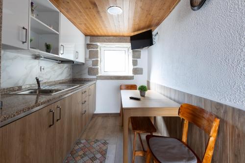 a small kitchen with a sink and a wooden table at Casa da Carqueija in Valezim