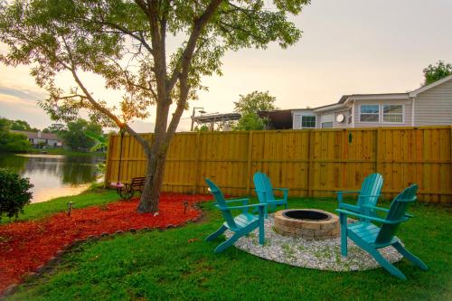 three chairs sitting around a fire pit in a yard at Savannah Lakefront Retreat near Tybee Beach with King Bed and Free Parking in Savannah