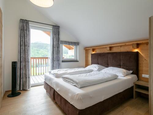 a bedroom with a large bed and a large window at Apart33 Top 2-12A in Haus im Ennstal