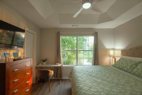 a bedroom with a bed and a desk and a window at Savannah Lakefront Retreat near Tybee Beach with King Bed and Free Parking in Savannah