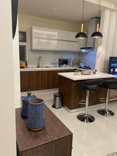 a kitchen with a counter and two bar stools at The Bliss Central - Elysium Tower Opp Centaurus Mall in Islamabad