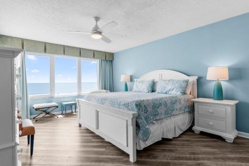 a bedroom with a bed with blue walls and a window at Litchfield Beach & Golf Resort in Pawleys Island
