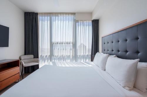 a bedroom with a large white bed with a large window at Level Los Angeles - Downtown South Olive in Los Angeles
