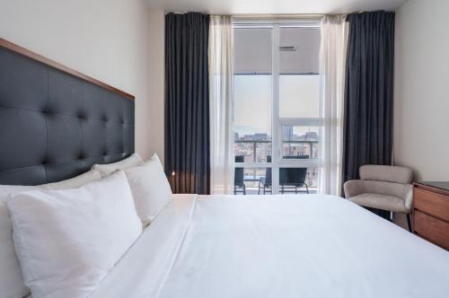 a bedroom with a large white bed and a window at Level Los Angeles - Downtown South Olive in Los Angeles