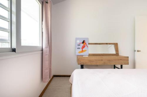 a bedroom with a bed and a table with a mirror at Fully equipped Bungalow next to a white sand beach in Moorea