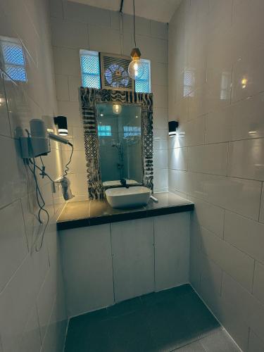 a bathroom with a sink and a mirror at Bali Stuti Jimbaran Inn in Jimbaran