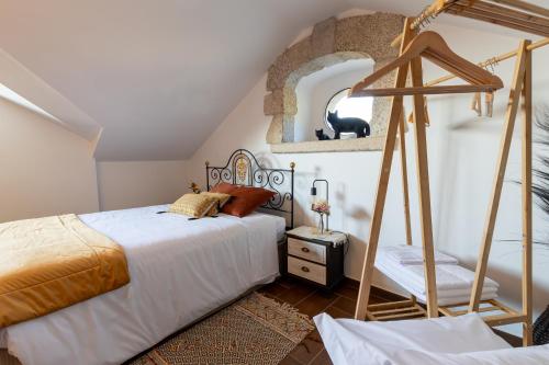 a bedroom with a bed and a mirror at Casas do Gato in Valezim