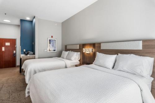 a hotel room with two beds with white sheets at Holiday Inn Express & Suites Maumelle by IHG in Maumelle