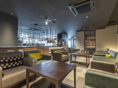 a lobby with couches and tables in a room at Tokyu Stay Sapporo Odori in Sapporo