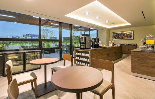 a kitchen with two tables and chairs and windows at Staybridge Suites - Guadalajara Novena by IHG in Guadalajara