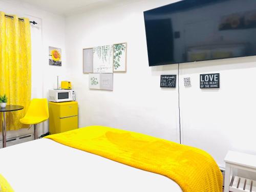 1 dormitorio con 1 cama con manta amarilla en IMPERIAL STAY BnB, en Brooklyn