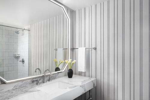 a white bathroom with a sink and a mirror at Omni Charlottesville Hotel in Charlottesville