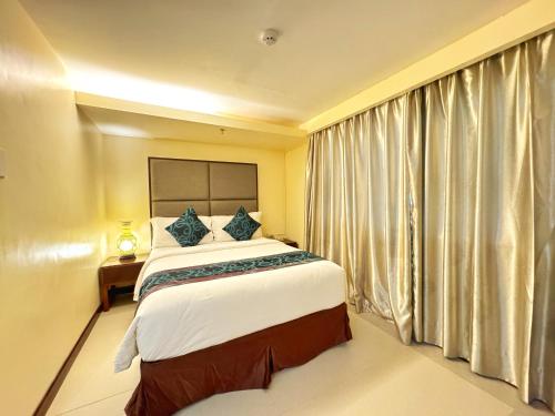 a bedroom with a large bed and a window at Golden Phoenix Hotel Boracay in Boracay