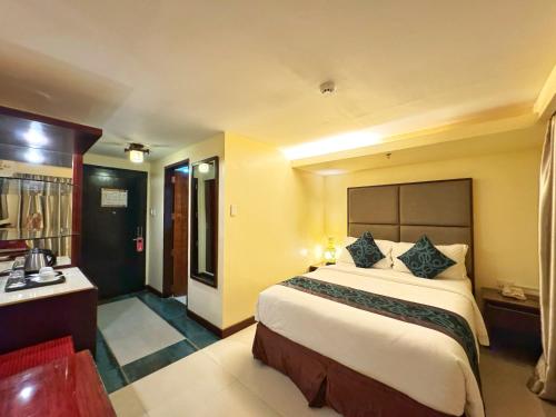 a hotel room with a large bed and a desk at Golden Phoenix Hotel Boracay in Boracay