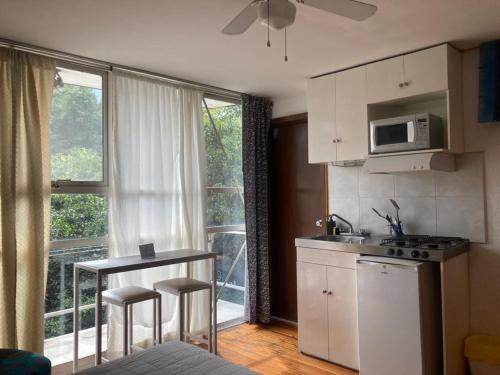 a kitchen with a sink and a stove and a window at Suites Portal San Ángel I Hospedaje Ejecutivo in Mexico City