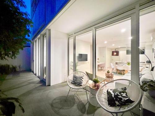a balcony with chairs and a table and a dining room at Indulge Luxury Holiday Near Brighton Beach with Private Garden Parking in Melbourne