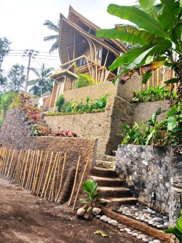 a building with stairs and plants in front of it at Danaswari Bali Bamboo House in Selat