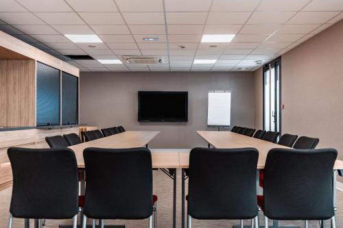 a conference room with tables and chairs and a tv at Holiday Inn Express Ajaccio by IHG in Ajaccio