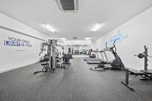 a gym with a row of treadmills and machines at Inner-City 2-Bed with Large Balcony, Garden & Gym in Campbell