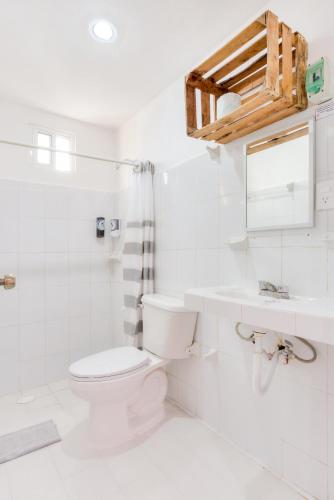 a white bathroom with a toilet and a sink at HOTEL LAS COLORADAS in Yuluc