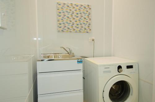 a kitchen with a washing machine and a sink at Tarawera River Lodge Motel in Kawerau