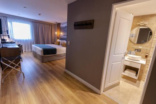 a hotel room with a bed and a bathroom at Alto Andino Hotel in Ushuaia