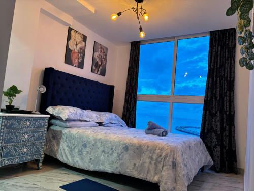 a bedroom with a bed and a large window at Apártamento Avenida balboa the Sands Vista al Mar Casco Viejo in Panama City